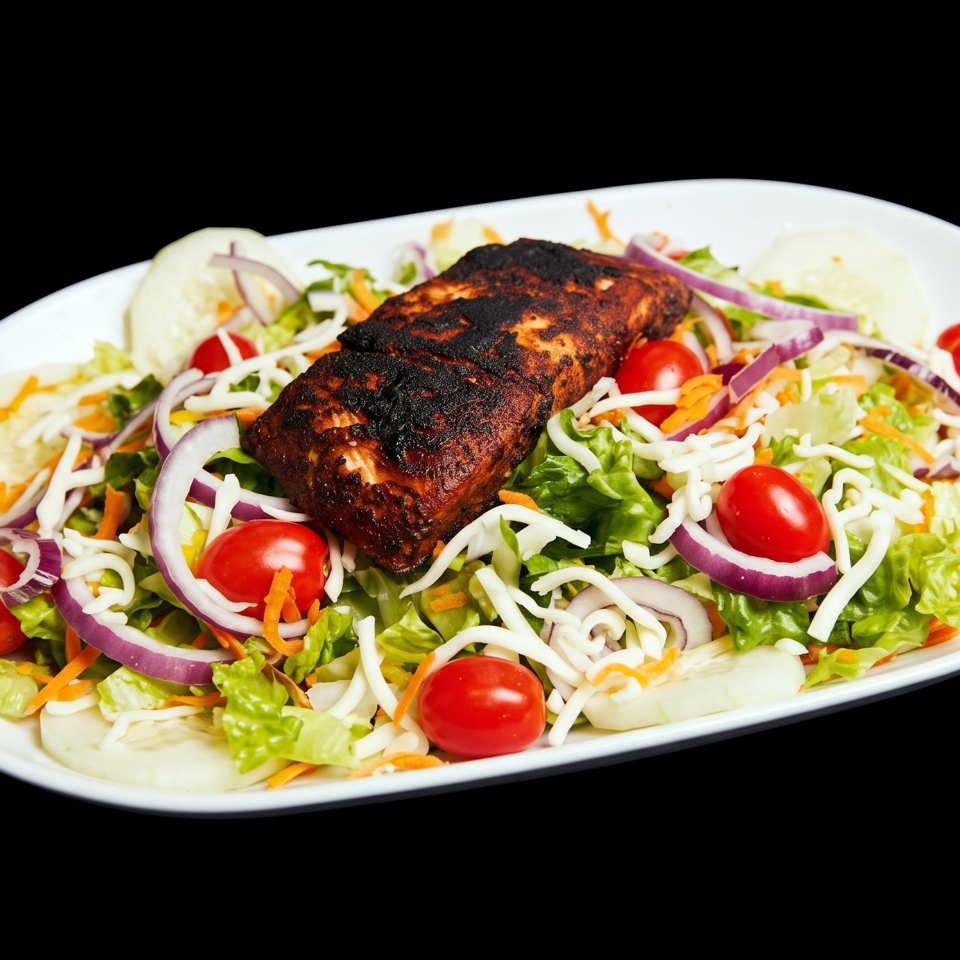 Grilled salmon fillet on a fresh garden salad with cherry tomatoes, red onions, and shredded carrots.